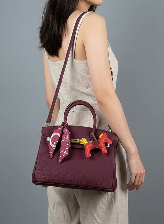 Birkin d'Hermès Cuir bordeaux et accessoires rouge et jaune.