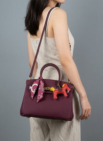 Birkin d'Hermès Cuir bordeaux et accessoires rouge et jaune.