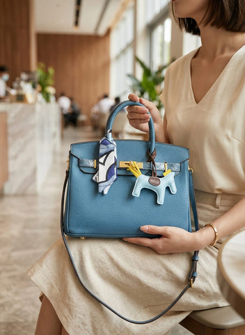 Birkin d'Hermès Cuir bleu jeans et accessoires bleu et jaune.