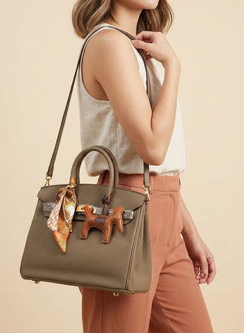 Birkin d'Hermès Cuir taupe et accessoires orange.