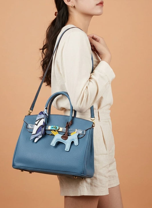 Birkin d'Hermès Cuir bleu jeans et accessoires bleu et jaune.